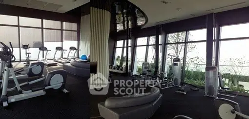 Luxurious gym with modern equipment and panoramic windows in upscale residential building.