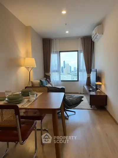 Modern living room with city view, stylish furniture, and natural light in a high-rise apartment.