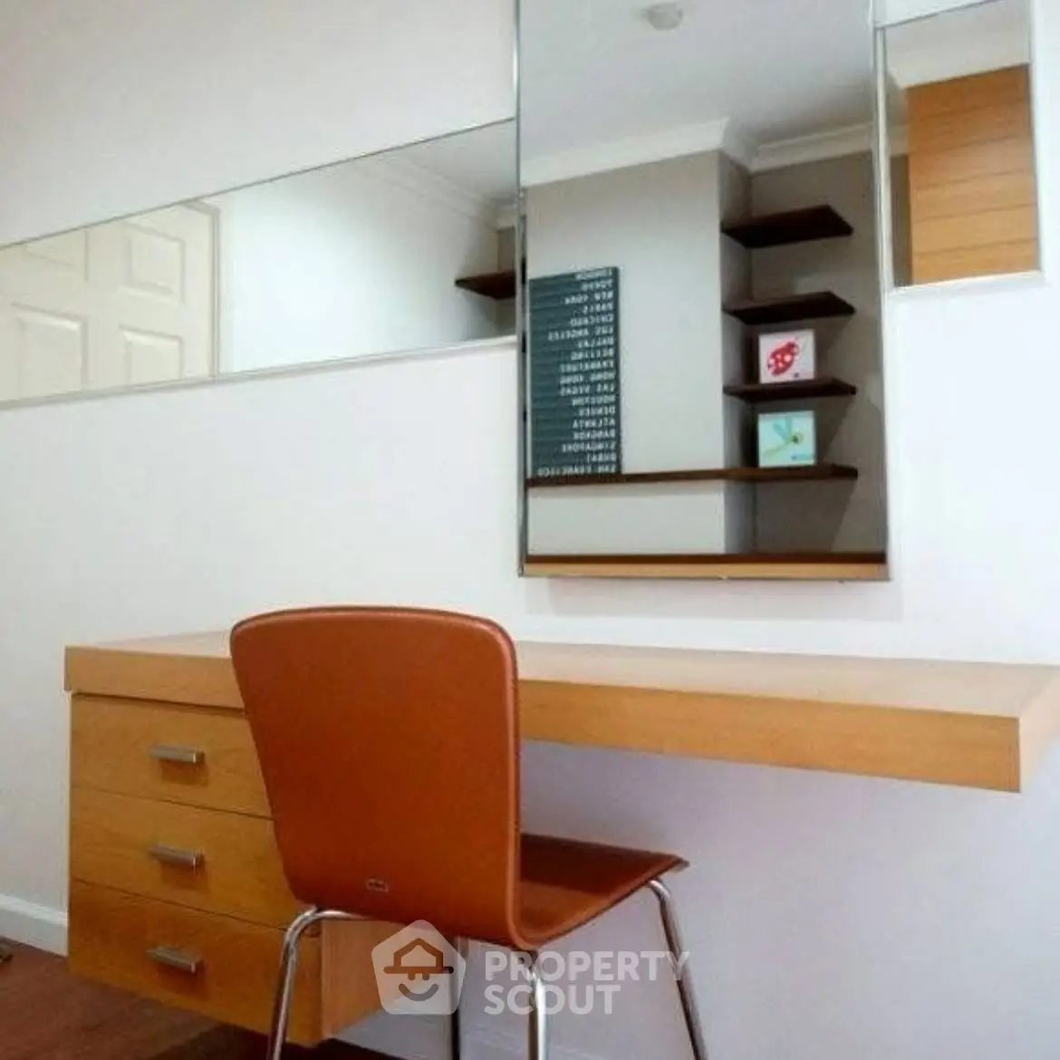 Modern study area with sleek desk, chair, and wall-mounted shelves in a stylish home office.