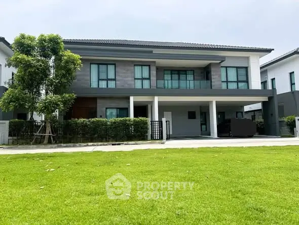 Modern two-story house with spacious lawn and contemporary design.