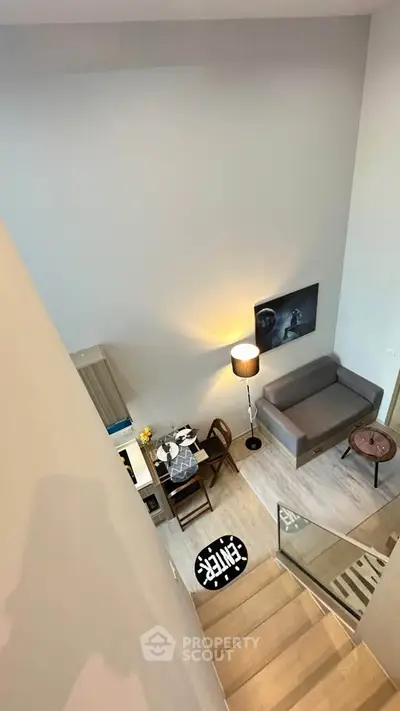 Modern loft-style living room with high ceiling and cozy furniture