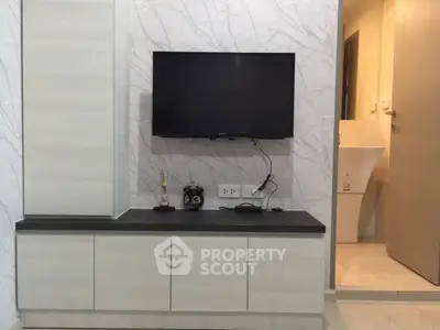 Modern living room with wall-mounted TV and sleek cabinetry, showcasing minimalist design.