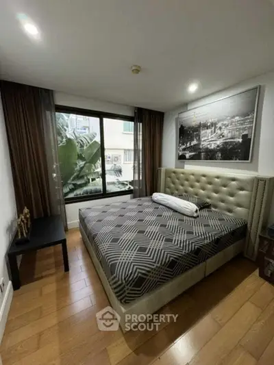 Modern bedroom with large window and stylish decor in urban apartment