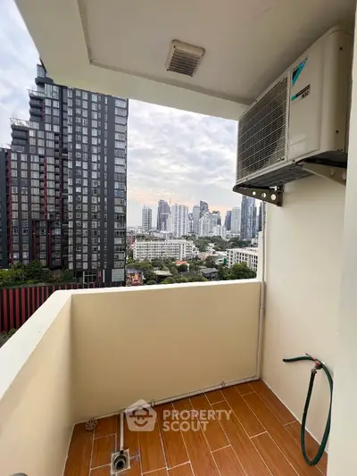 High-rise balcony with city skyline view and air conditioning unit