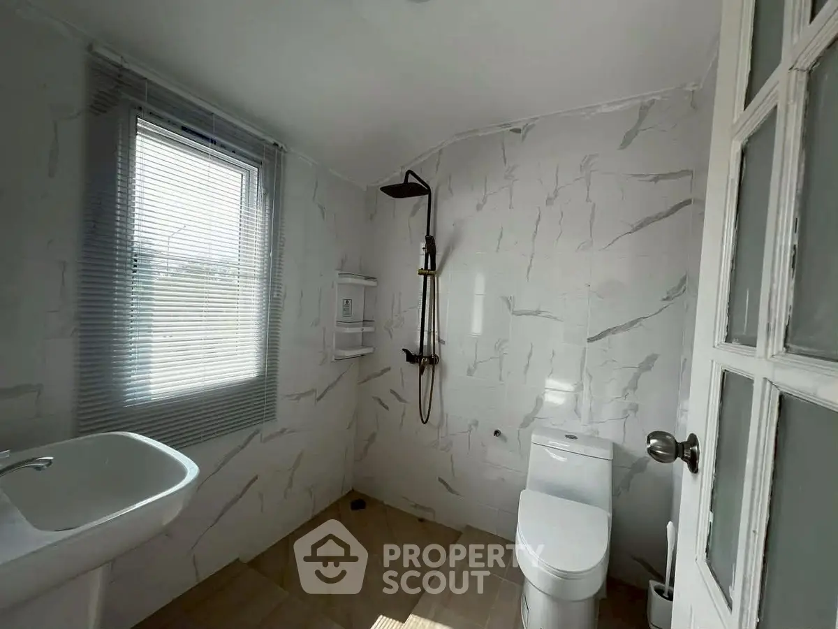 Modern bathroom with sleek fixtures and natural light from window.