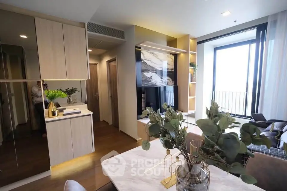 Modern living room with elegant decor and large windows offering natural light and balcony access.