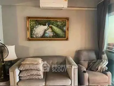 Cozy living room with elegant sofa, armchair, and peacock painting, perfect for relaxation.