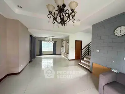 Spacious living room with elegant chandelier and modern staircase