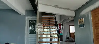 Modern interior with wooden staircase and blue walls, showcasing open space design.