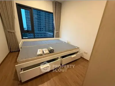 Modern bedroom with large window and wooden flooring in urban apartment