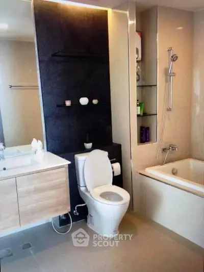 Modern bathroom with sleek fixtures and built-in shelving, featuring a bathtub and contemporary design.