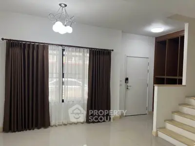 Spacious living room with elegant curtains and modern lighting, perfect for cozy family gatherings.