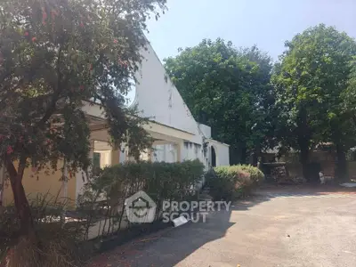 Charming rustic property with lush greenery and spacious outdoor area, perfect for serene living.