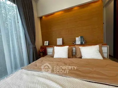 Cozy bedroom with modern decor and large window for natural light