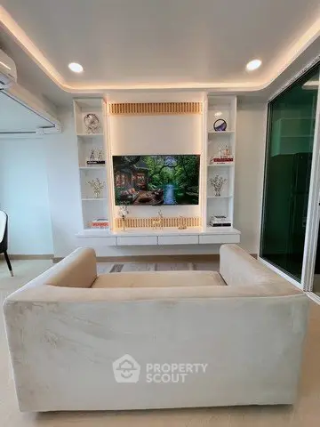 Modern living room with elegant built-in shelving and cozy sofa, perfect for relaxation and entertainment.