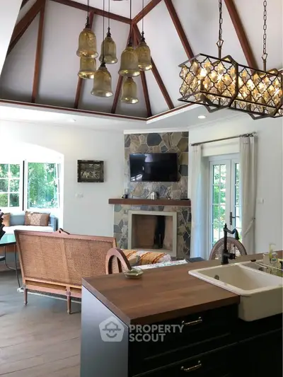 Charming living room with vaulted ceiling and rustic stone fireplace