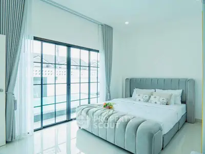 Luxurious bedroom with plush bed and large window offering natural light