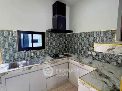 Modern kitchen with marble countertops and stylish backsplash in a contemporary home.