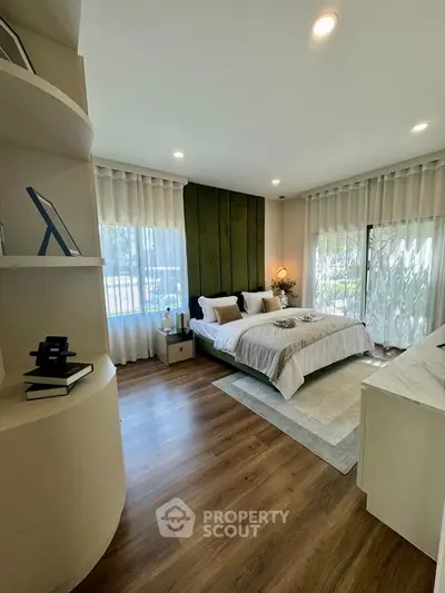 Luxurious bedroom with elegant decor and large windows offering natural light