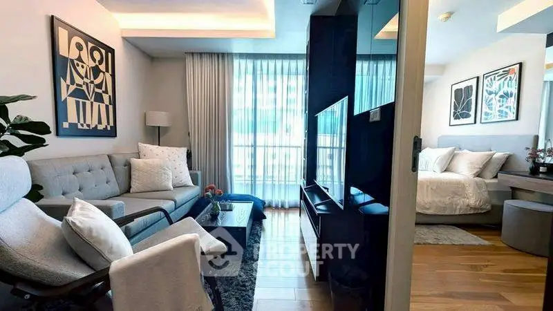 Modern open-plan living room and bedroom with stylish decor and natural light.