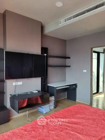 Modern bedroom with sleek furniture and red bedding in a stylish apartment.
