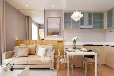 Modern living room with cozy beige sofa and stylish dining area in open-plan layout.