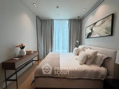Elegant bedroom with modern decor, featuring a large bed, stylish artwork, and natural light through floor-to-ceiling windows.