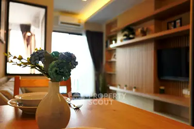Modern living room with stylish decor and wooden furniture, featuring a cozy dining area and elegant shelving.