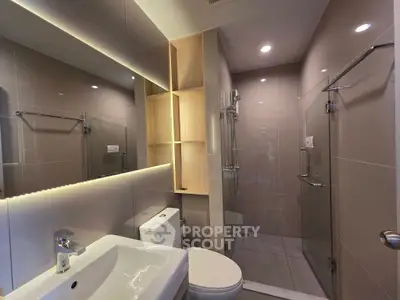 Modern bathroom with sleek design, glass shower, and ambient lighting.