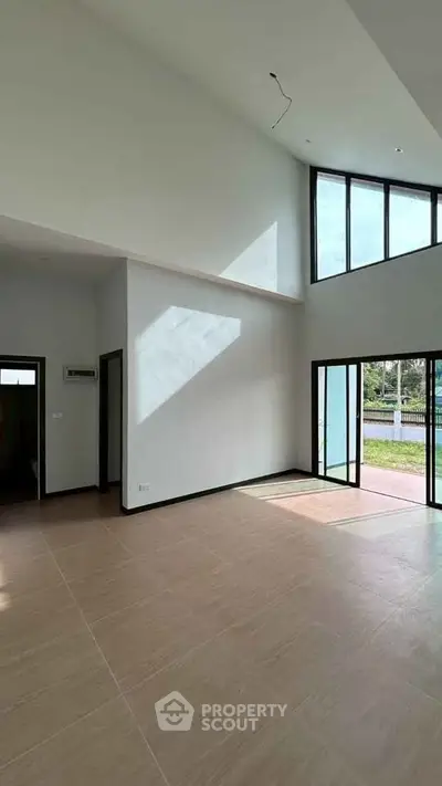 Spacious modern living room with high ceilings and large windows offering natural light
