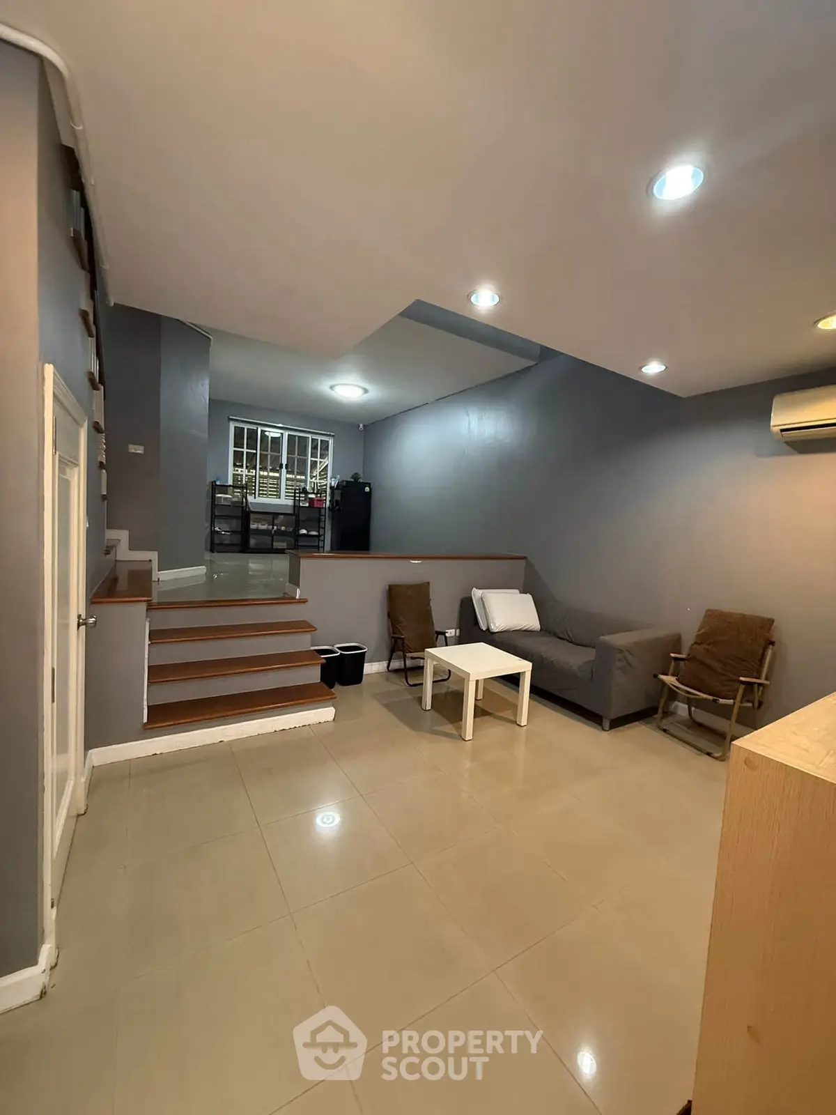 Spacious living room with modern decor and cozy seating area, perfect for relaxation and entertainment.