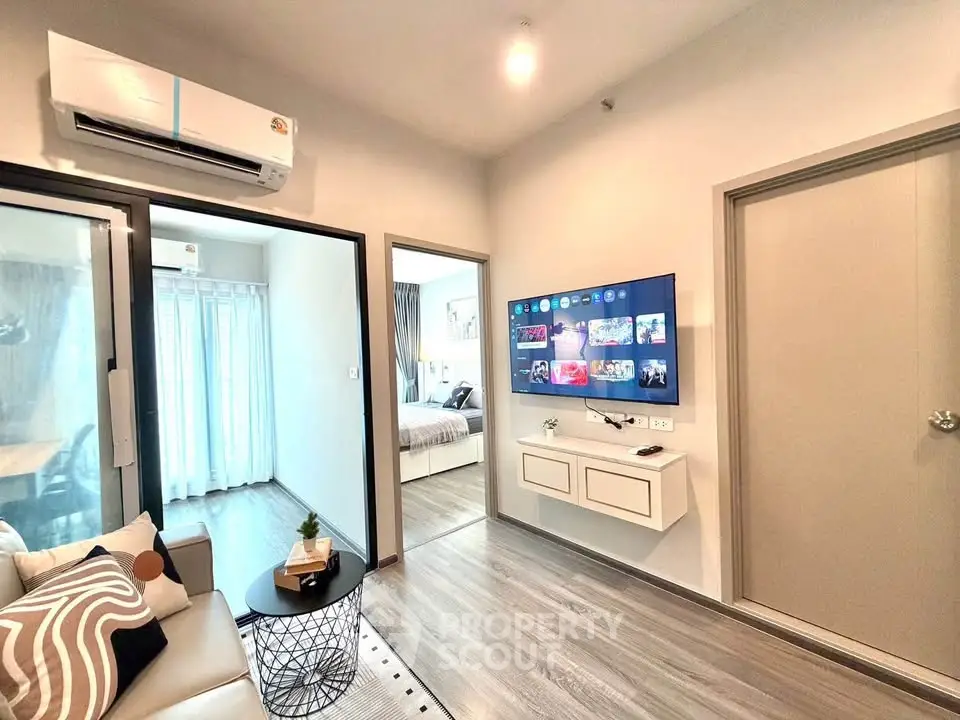 Modern living room with sleek decor and wall-mounted TV in a stylish apartment.