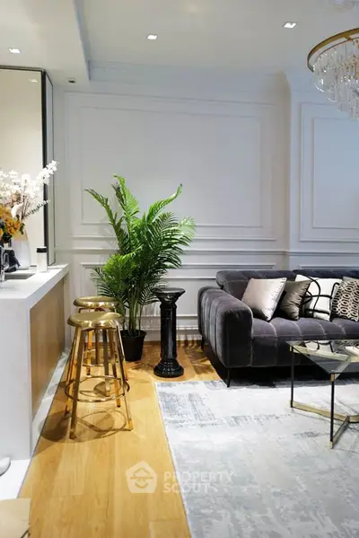 Luxurious living room with elegant decor, plush sofa, and stylish bar stools in a modern apartment.