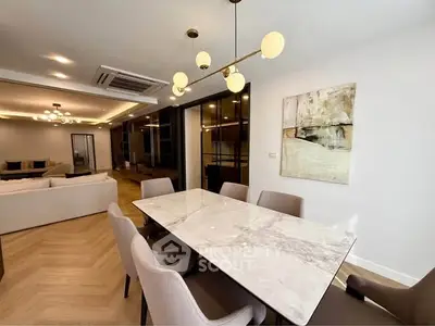 Spacious modern living room with elegant dining area and stylish lighting fixtures.