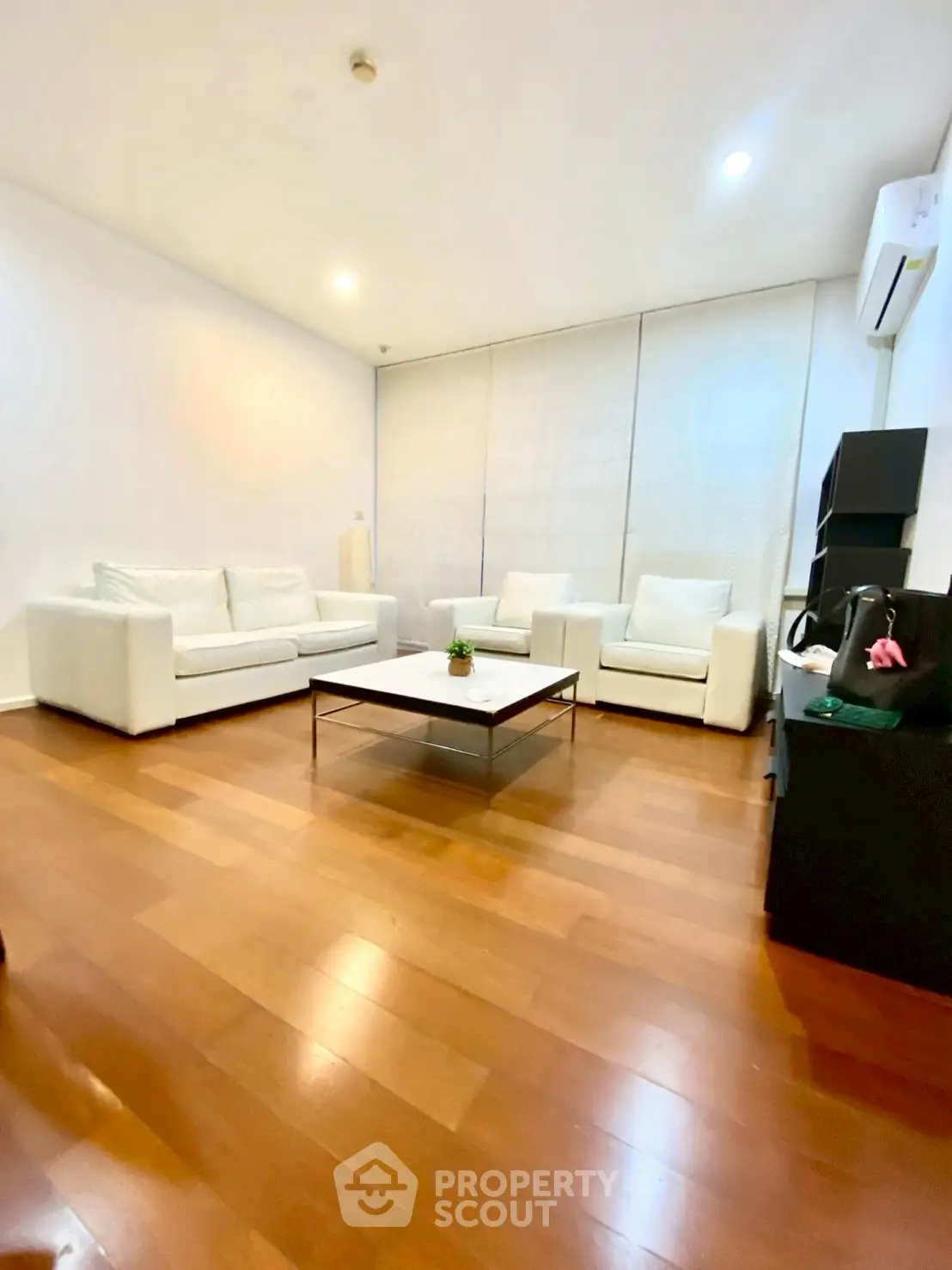 Spacious modern living room with elegant white sofas and wooden flooring