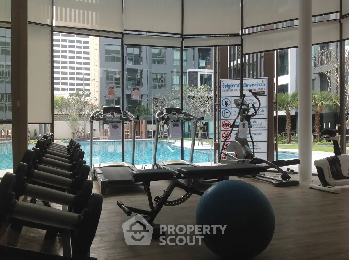 Modern gym with pool view in luxury residential complex