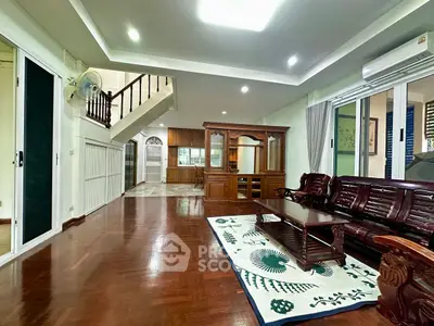 Spacious living room with wooden flooring and elegant furniture in a modern home.