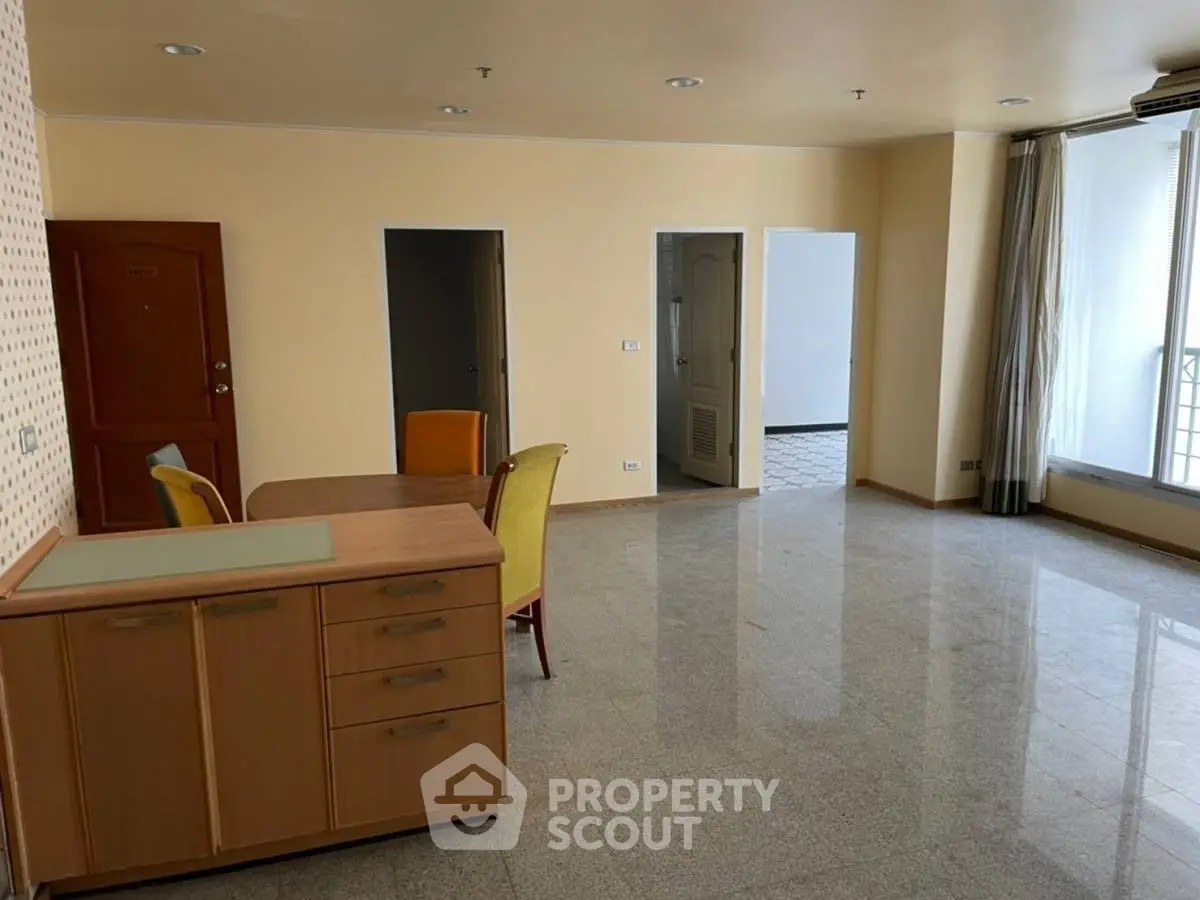Spacious living room with dining area and large windows in modern apartment