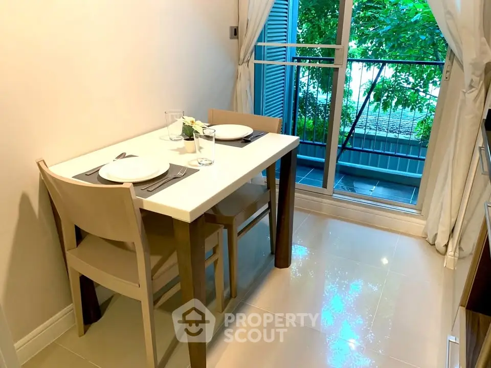 Cozy dining area with natural light and balcony view, perfect for intimate meals.