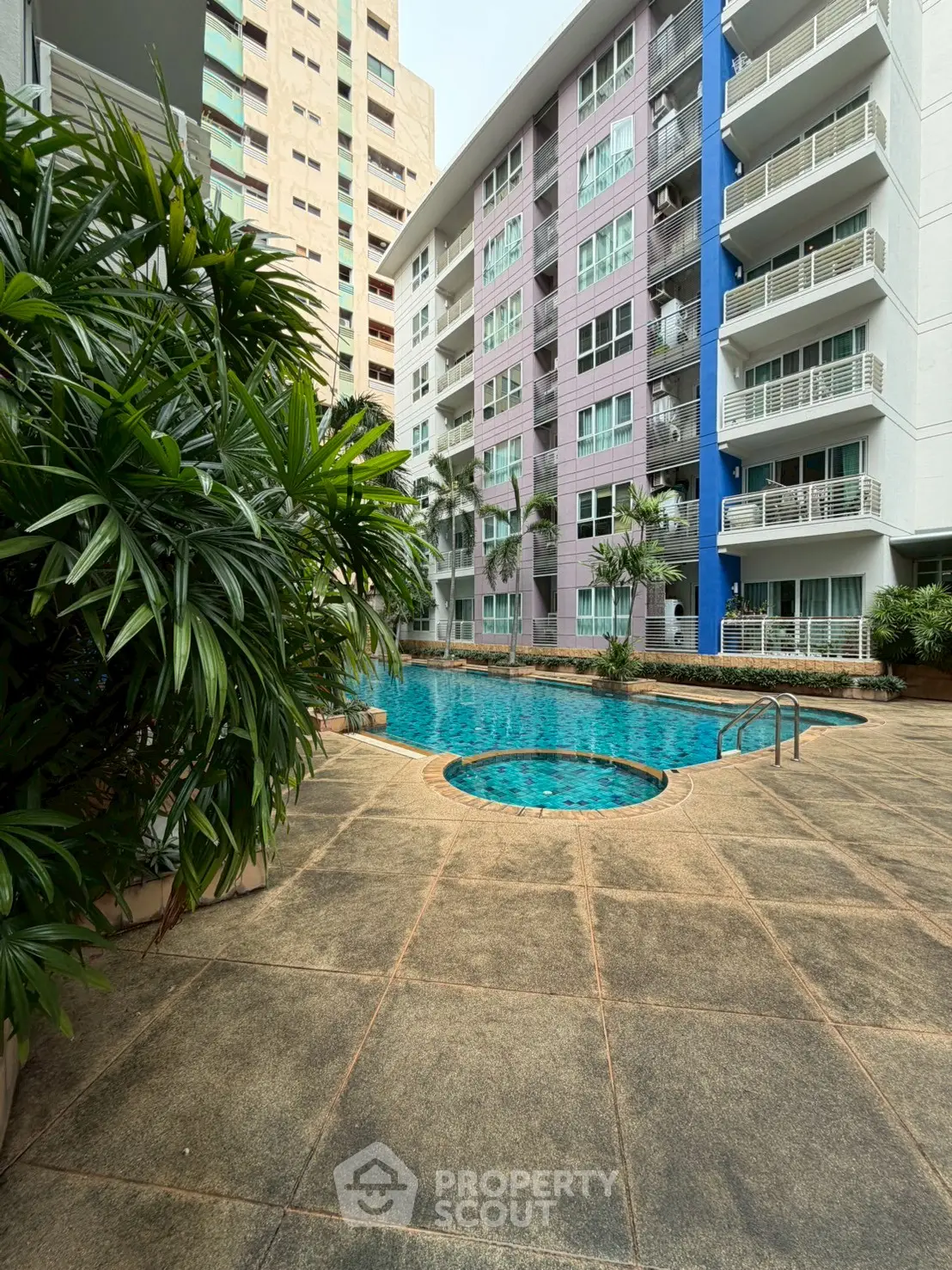 Luxurious apartment complex with a stunning pool and lush greenery, perfect for relaxation and leisure.