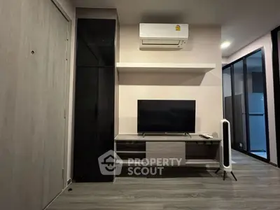 Modern living room with sleek TV stand and air conditioning unit, featuring minimalist design.