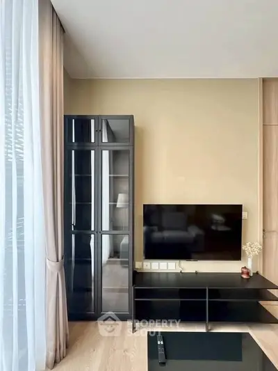 Modern living room with sleek black TV stand and glass cabinet
