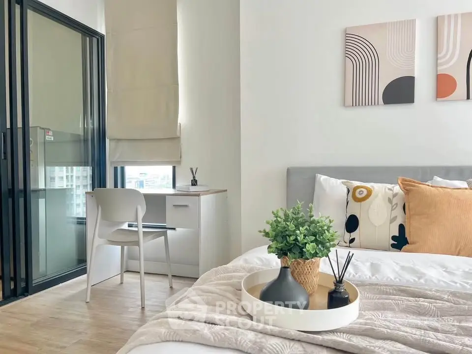 Modern bedroom with stylish decor and natural light, featuring a cozy workspace and elegant furnishings.