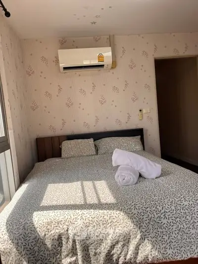 Cozy bedroom with air conditioning and floral wallpaper, perfect for relaxation.