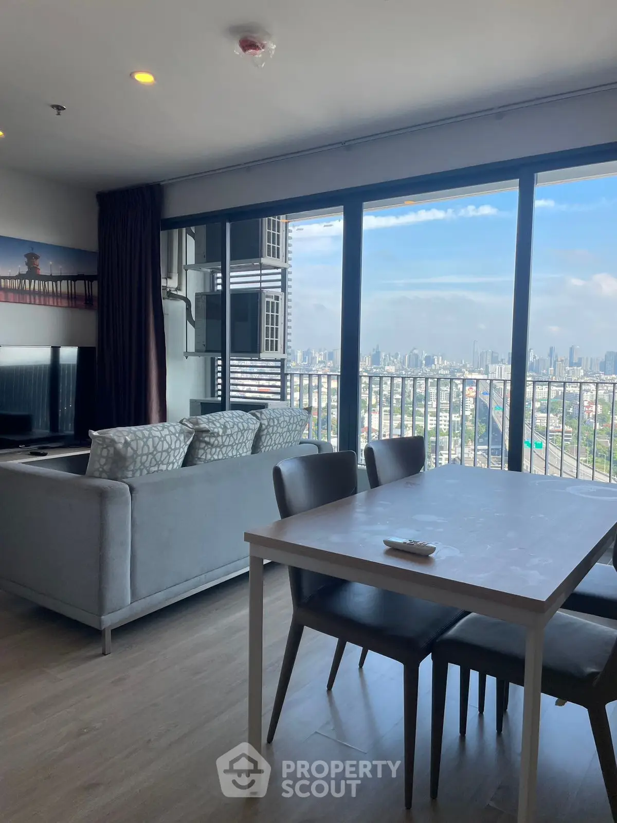 Modern living room with stunning city view and elegant dining area