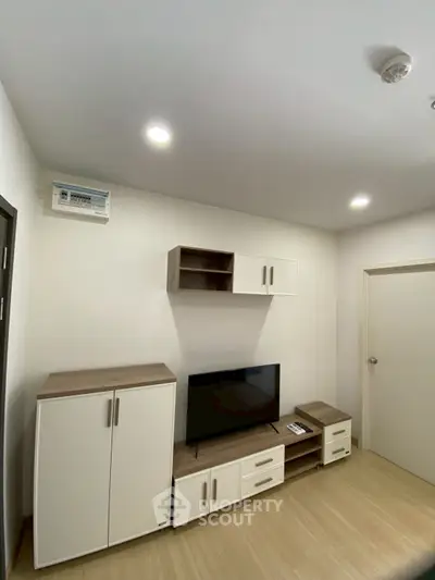 Modern living room with sleek TV stand and storage cabinets, perfect for cozy entertainment.