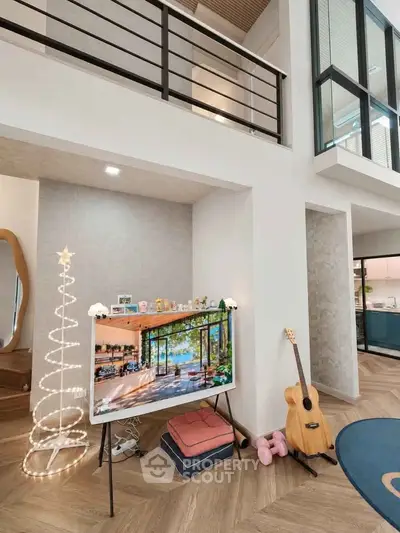 Modern living room with stylish decor and guitar, featuring open layout and high ceilings.