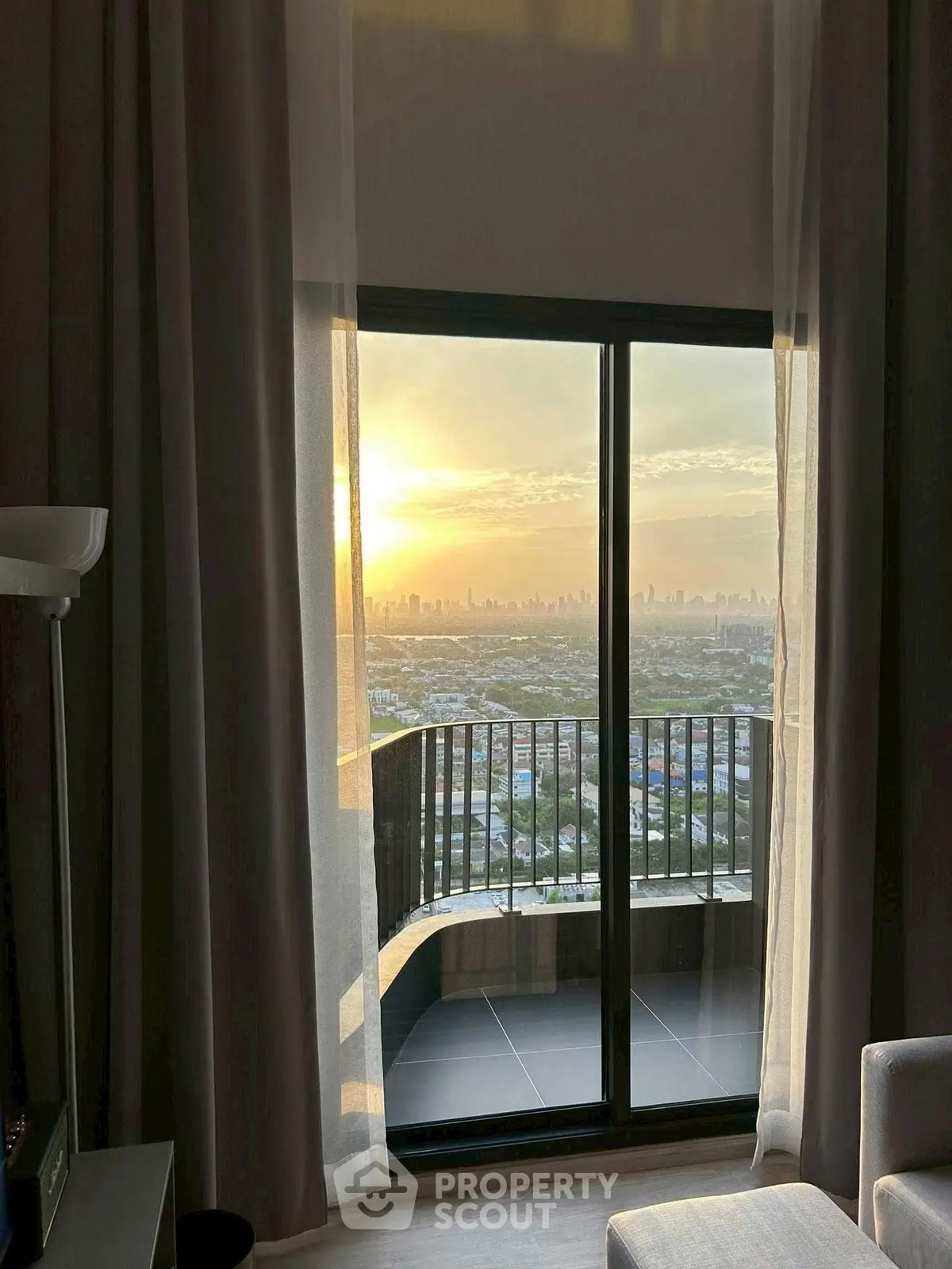 Stunning cityscape view from high-rise balcony at sunset, perfect for urban living.