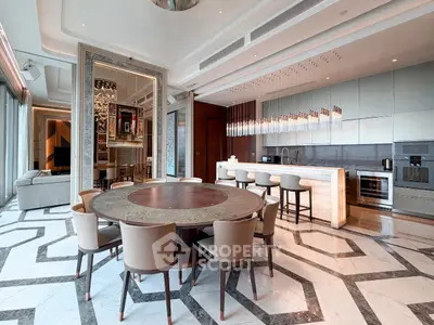 Luxurious open-plan living room and kitchen with elegant dining area and modern lighting.