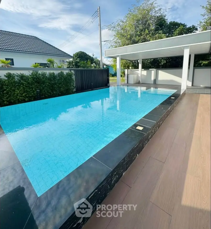 Luxurious modern outdoor pool with sleek design and spacious deck area.